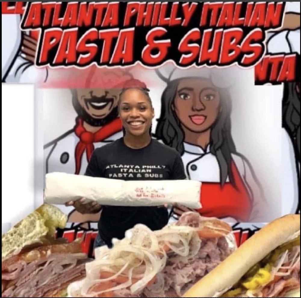 Team member holding a foot-long Italian sub